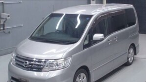 Ein silberner Minivan mit klarem, modernem Design steht in einem Innenraum.