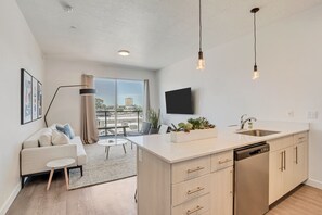 A modern apartment with a kitchen, dining area, and living room. - LCF - Downtown Salt Lake City - Granary - 1 King BR/1BA - CoWork + Gym - Garage (Salt Lake City)