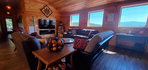 A cozy cabin interior with a TV, seating area, and large windows. - The Barn at Frog Hollow, Delano.  Rare find with 5 bedrooms, sleeps up to 15! (Delano)