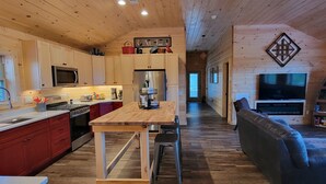Un interno rustico con cabina, cucina, sala da pranzo e soggiorno.