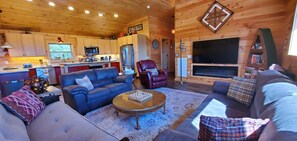 A cozy log cabin interior with a living room, a fireplace, a kitchen, and a dining area. - The Barn at Frog Hollow, Delano.  Rare find with 5 bedrooms, sleeps up to 15! (Delano)