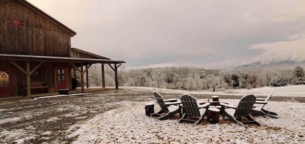A rustic wooden building with a covered porch and a snow-covered landscape in the background. - The Barn at Frog Hollow, Delano.  Rare find with 5 bedrooms, sleeps up to 15! (Delano)
