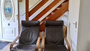A door with the number 250, a glass door with a decorative design, and two leather chairs with wooden frames. - Kingfisher Cottage Caernarfon-river rambling & relaxing, in a beautiful setting  (Caernarfon)