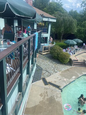 Ein Poolbereich mit Whirlpool, Liegestühlen und Sonnenschirmen.