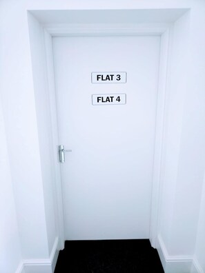 A white door with two labels: 'FLAT 3' and 'FLAT 4'. - Modern City Centre Apt Near Theatre & Marina (Kingston upon Hull)