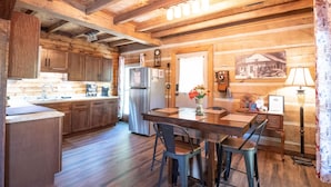 A rustic wooden interior with a kitchen, dining area, and a vintage lamp. - Updated pet friendly, close to Nashville! (Nashville)