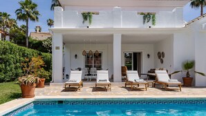 A poolside area with lounge chairs and a pool.