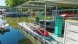 A marina with boats docked under covered areas, a water pump, and a ladder. - Quiet Lakefront - Hot Tub! H2O Toys! Pet Friendly! (Linn Creek)