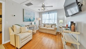 A living room with two sofas, a coffee table, a TV, and a bookshelf.