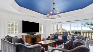A living room with a large flat-screen TV, a wooden coffee table, and a sofa set.