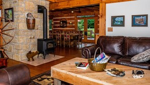 Ein rustikales Interieur mit Steinwand, Holzboden, Ledersofa, Couchtisch mit Zeitschriften und Kamin.