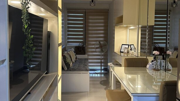 A modern kitchen with a dining area, featuring a central island, pendant lights, and a large mirror. - Mel and Rose Place at S Residences Tower 1 Mall of Asia Area (Pasay)