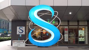 A modern building with a large illuminated 'S' logo and a sign for 'RESIDENCES'. - Mel and Rose Place at S Residences Tower 1 Mall of Asia Area (Pasay)