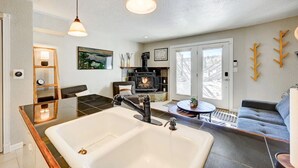 Ein modernes Wohnzimmer mit einer großen, weißen Badewanne, einem Kamin und einer gemütlichen Sitzecke.