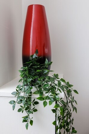 A red vase with a gradient effect, placed on a white surface. - Hibbert Galore (Barrow-in-Furness)