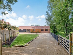 A two-story building with a gravel driveway and a wooden fence. - The Gallery Barn - UK39368 (Swafield)