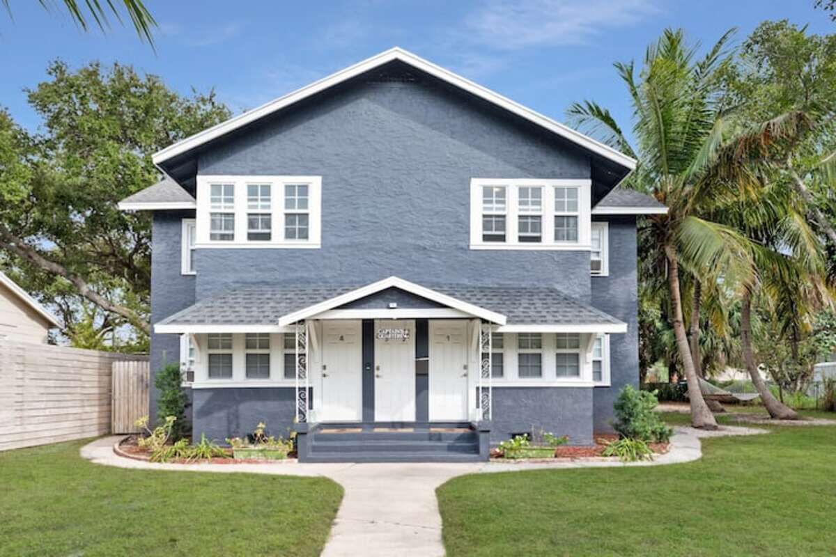 A two-story house with a front porch, a driveway, and a well-maintained lawn.