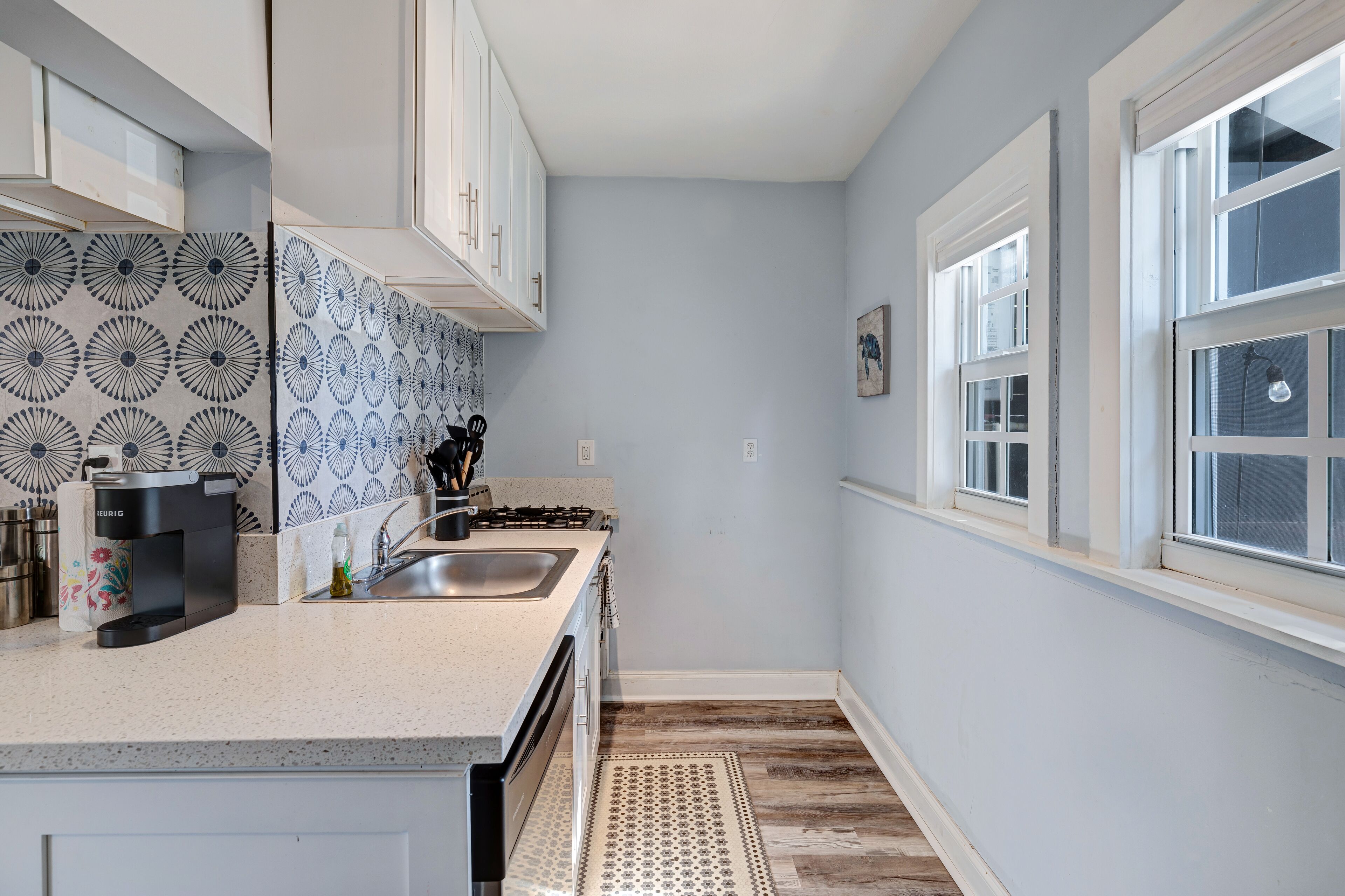 A kitchen with a countertop, sink, and backsplash.