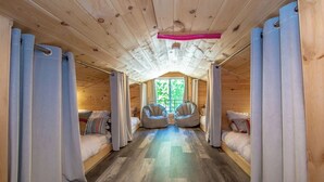 A cabin with two beds, a ceiling fan, and a view of greenery outside. - The Winsor Lodge | Saco River Group Retreat with Bar, Arcade, Hot Tub & Sauna (Conway)