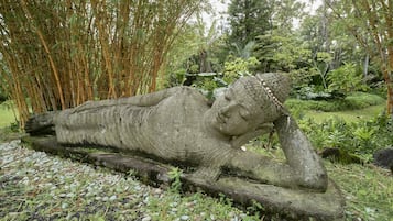 Eine steinerne Buddha-Statue in einem Garten.