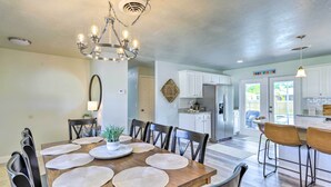 A dining area with a wooden table, chairs, and a chandelier. - Merritt Island Oasis w/ Pool ~ 7 Mi to Beach! (Merritt Island)