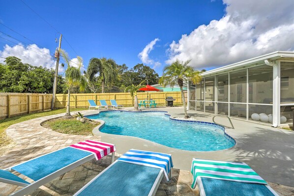 A swimming pool with lounge chairs and a covered area. - Merritt Island Oasis w/ Pool ~ 7 Mi to Beach! (Merritt Island)