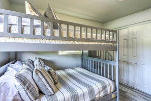 A bunk bed with striped bedding and pillows, a white door, and a wooden floor. - Merritt Island Oasis w/ Pool ~ 7 Mi to Beach! (Merritt Island)