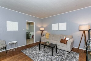 A living room with a sofa, coffee table, and lamps.