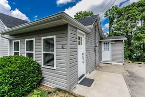 A single-story house with a grey siding exterior, a front door, and a small porch area.
