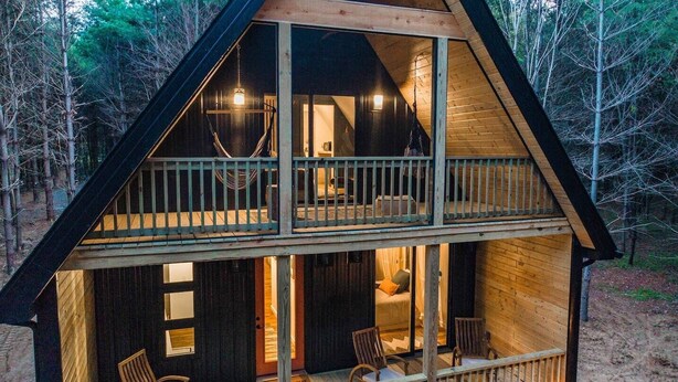 Une cabine à deux étages, dotée d’un balcon au niveau supérieur et dont l’intérieur est visible, avec un lit et un coin salon.