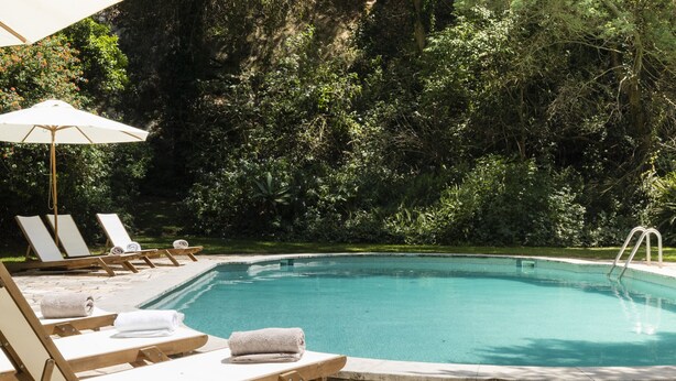 Ein Poolbereich mit Liegestühlen und Sonnenschirm.
