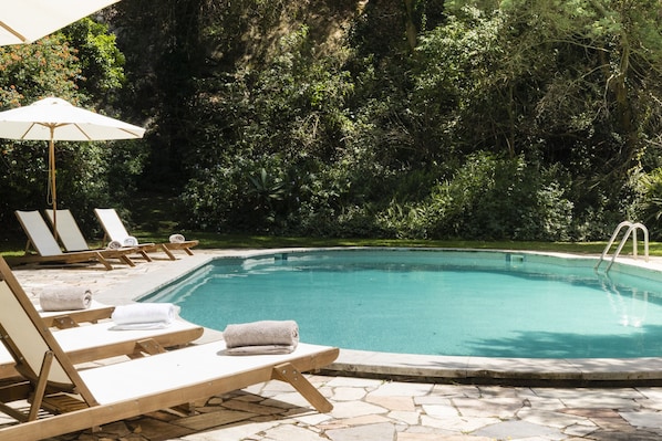 A poolside area with lounge chairs and a pool.