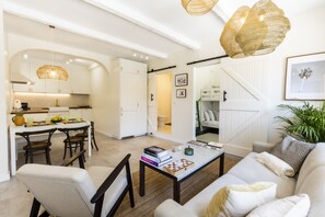 Een moderne woonkamer met een bank, salontafel en een eetgedeelte met stoelen en een tafel.