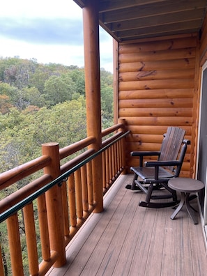 Relax in a peaceful forest setting from this deck with a single Adirondack chair.
