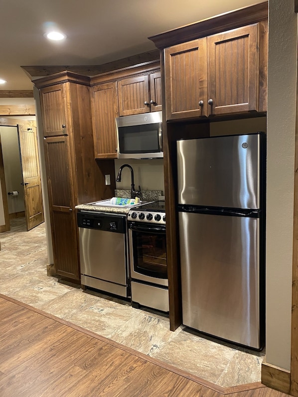 Enjoy cooking in this well-equipped kitchen with a microwave, oven, and refrigerator.