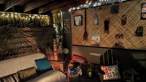 Un'accogliente area relax con divano, un tavolino con una candela e insegna del tiki bar.