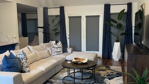 Ein modernes Wohnzimmer mit einer Couch, einem Couchtisch und einem Deckenventilator.
