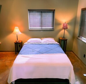 A bedroom with a bed, two bedside tables, a window with blinds, and a lamp on each side of the bed. - NW Modern, River, Old Mill near Downtown (Bend)