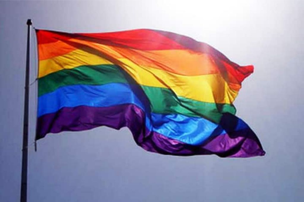 Una bandera con franjas horizontales en rojo, naranja, amarillo, verde, azul y morado.