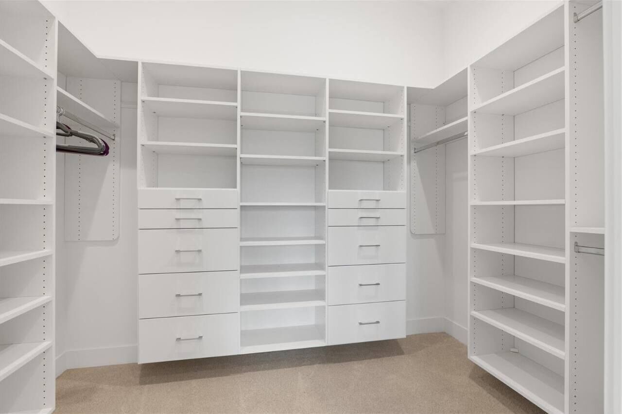 Um closet espaçoso com várias prateleiras e gavetas, organizado para armazenamento.