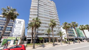 Un hotel moderno e slanciato, con diversi balconi e facciata in vetro.
