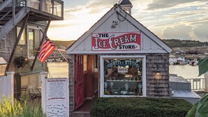 A small ice cream store with a red door and an American flag.