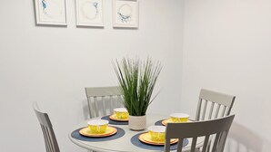Un comedor con una mesa redonda, cuatro sillas y una planta en maceta.