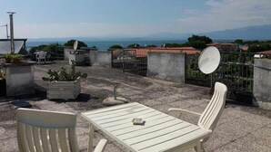 A rooftop terrace with a table and chairs, satellite dishes, and potted plants. - Residence Florida B10 - 200m from the lakefront (Lazise)