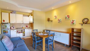 A compact living space with a kitchenette, dining area, and a sofa. - Residence Florida B10 - 200m from the lakefront (Lazise)