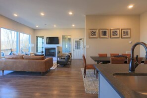 A spacious living area with a sofa, a dining table, and a kitchen area with a sink.