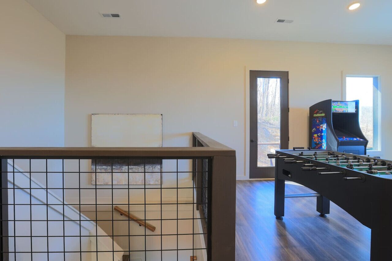 Una habitación con mesa de fútbol, televisión y ventana.