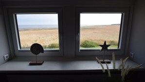 A room with two windows overlooking a field. - House Stedum Apartment 19 (Sylt)