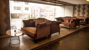 A room with a sofa set, a small table, and a large window with a view of buildings. - Q Collection @ Macalister(formerly know as Apple Hotel Penang)  (George Town)