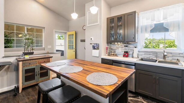 Una cocina moderna con una isla de madera, armarios empotrados y un amplio ventanal que proporciona luz natural.